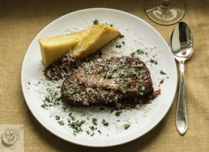 Plated Italian Meatloaf with Polenta and Spicy Sauce.