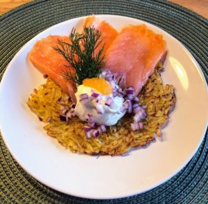 Plated cold smoked salmon, råraka, rödlök with crème fraiche.
