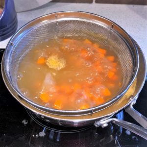 Poaching the veggies in fish stock.