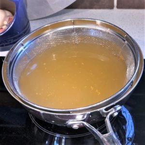 Fish stock heating for poaching the veggies.