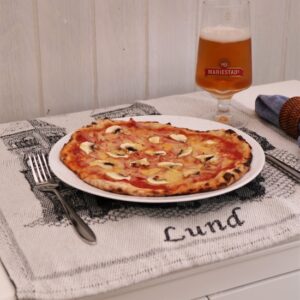 A Swedish capricciosa pizza, on a plate.